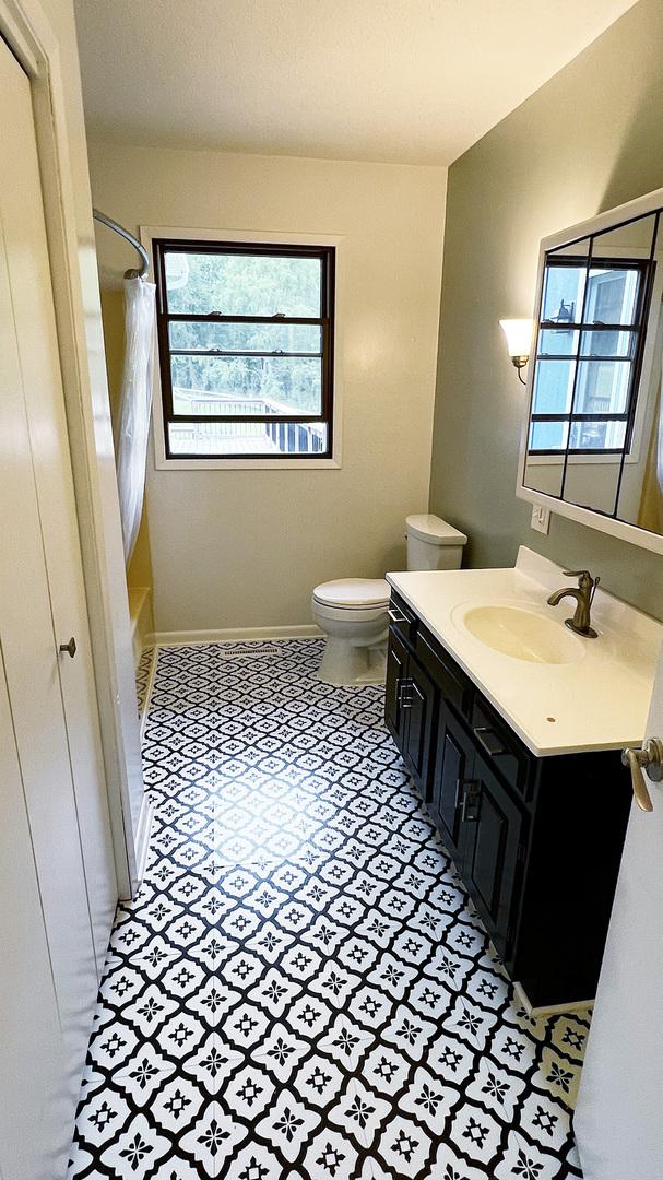 15501 Bishop Rd, Morrison, IL 61270 - full bathroom with vanity, toilet, baseboards, and shower / bath combo