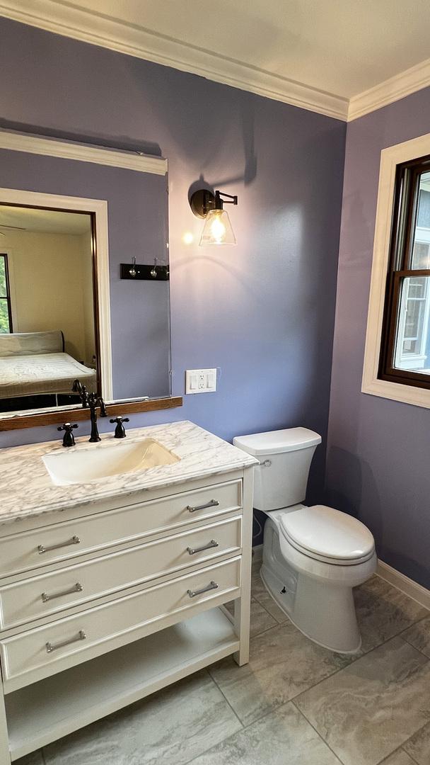 15501 Bishop Rd, Morrison, IL 61270 - bathroom featuring crown molding, vanity, toilet, and baseboards