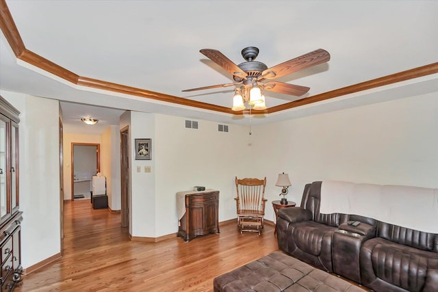 8702 Bally Castle Ln, Tinley Park, IL 60487 - living area featuring a raised ceiling, light wood-type flooring, a ceiling fan, and baseboards