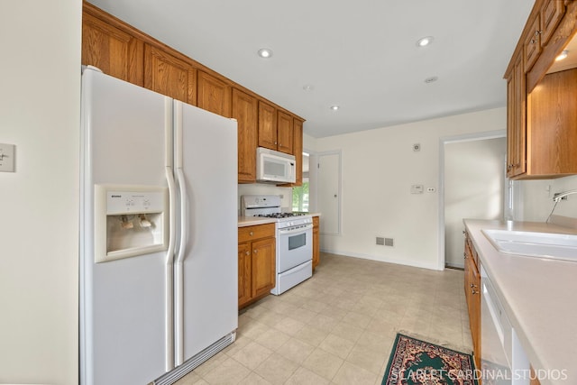 275 E Division St, Villa Park, IL 60181 - kitchen with white appliances, a sink, brown cabinets, light countertops, and recessed lighting