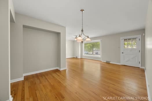 275 E Division St, Villa Park, IL 60181 - unfurnished dining area with healthy amount of natural light, a chandelier, wood finished floors, and baseboards