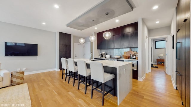 1203 W Superior St Unit 1C, Chicago, IL 60642 - kitchen with modern cabinets, light countertops, a breakfast bar area, light wood-style floors, and recessed lighting