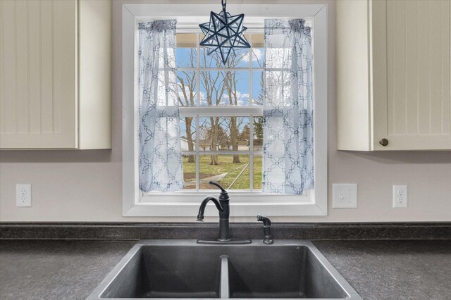 2225 County Road 1700 N, Saint Joseph, IL 61873 - kitchen view of a sink, dark countertops, white cabinetry, and a chandelier