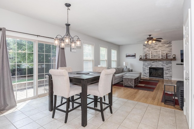 1710 Fraser Dr, Normal, IL 61761 - dining area with light tile patterned floors, ceiling fan, a large fireplace, and a chandelier