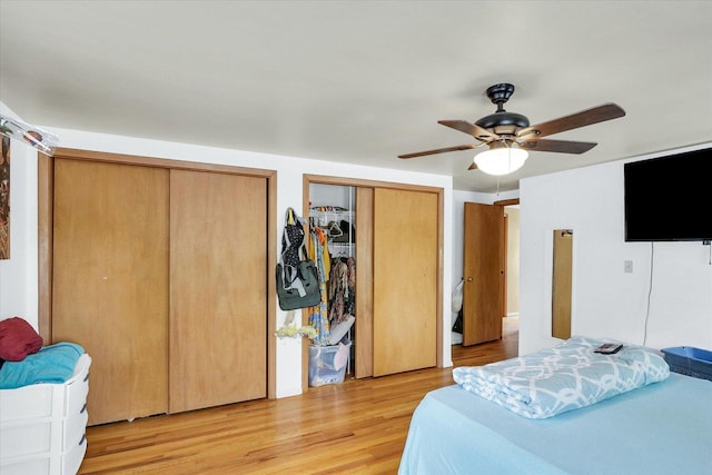 1117 W Springfield Ave, Champaign, IL 61821 - bedroom with two closets, light wood-type flooring, and ceiling fan