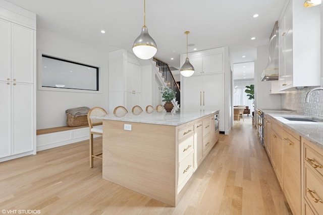 2014 N Winchester Ave, Chicago, IL 60614 - kitchen with a sink, light wood-type flooring, a kitchen breakfast bar, a spacious island, and tasteful backsplash