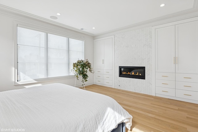 2014 N Winchester Ave, Chicago, IL 60614 - bedroom with a glass covered fireplace, light wood finished floors, and ornamental molding