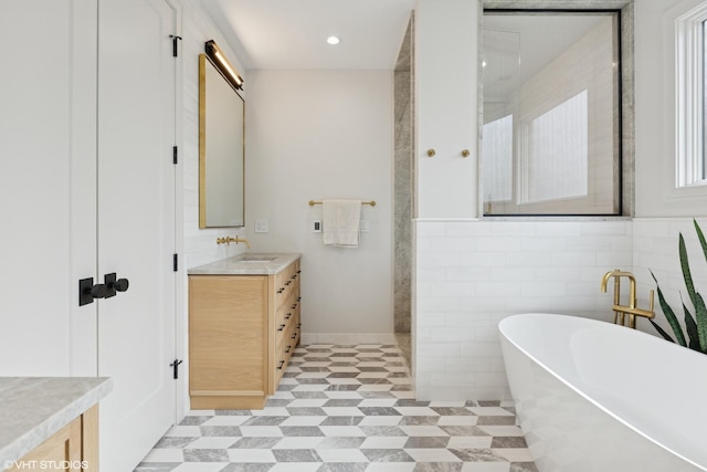 2014 N Winchester Ave, Chicago, IL 60614 - bathroom featuring vanity, a soaking tub, walk in shower, baseboards, and tile walls