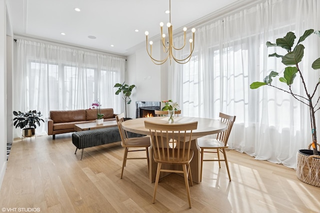 2014 N Winchester Ave, Chicago, IL 60614 - dining area with light wood finished floors, a lit fireplace, and a chandelier
