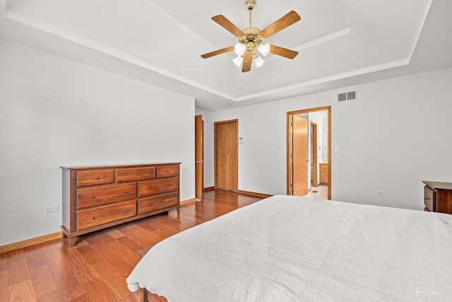 2048 Westbury Dr, Woodridge, IL 60517 - bedroom featuring a tray ceiling, wood finished floors, connected bathroom, and a ceiling fan