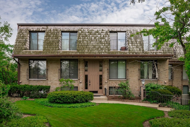 1700 Northfield Sq Unit C, Northfield, IL 60093 - view of front of home featuring a front yard, mansard roof, and brick siding