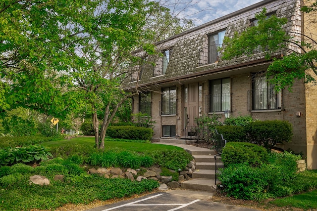 1700 Northfield Sq Unit C, Northfield, IL 60093 - view of front of property featuring uncovered parking, brick siding, and mansard roof