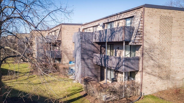 1700 Northfield Sq Unit C, Northfield, IL 60093 - view of side of home with a balcony, brick siding, and mansard roof