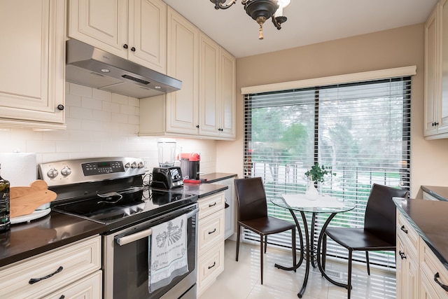 1700 Northfield Sq Unit C, Northfield, IL 60093 - kitchen with under cabinet range hood, electric range, dark countertops, tasteful backsplash, and light tile patterned floors