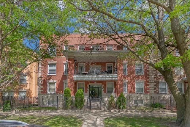 4137 S Prairie Ave Unit 3, Chicago, IL 60653 - townhome / multi-family property with a balcony, a fenced front yard, brick siding, and a gate
