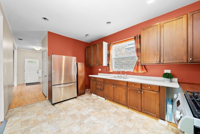 7809 S Peoria, Chicago, IL 60620 - kitchen with freestanding refrigerator, a sink, gas range oven, light countertops, and brown cabinetry