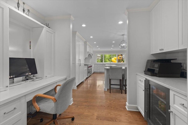 1410 Wincanton Dr, Deerfield, IL 60015 - home office featuring beverage cooler, recessed lighting, light wood-style floors, ornamental molding, and built in desk