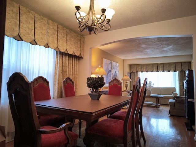 10153 S Saint Lawrence Ave, Chicago, IL 60628 - dining room with arched walkways, a chandelier, wood finished floors, and a textured ceiling