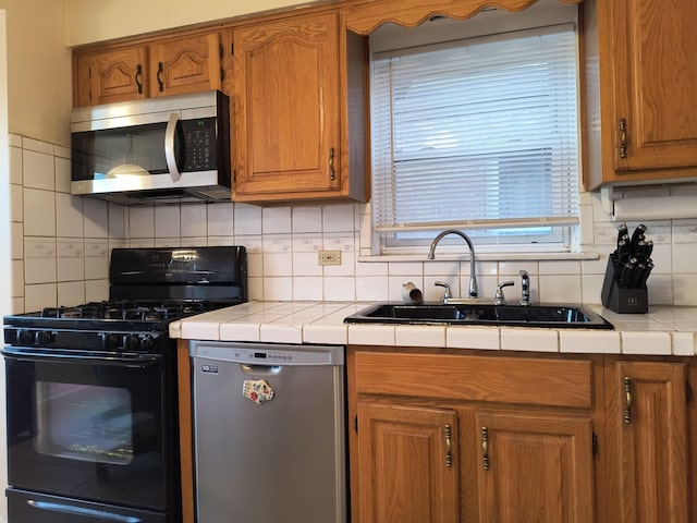 10153 S Saint Lawrence Ave, Chicago, IL 60628 - kitchen with appliances with stainless steel finishes, tile countertops, decorative backsplash, and brown cabinetry
