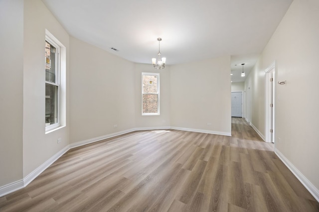 5622 S Laflin St, Chicago, IL 60636 - unfurnished room featuring a chandelier, wood finished floors, and baseboards