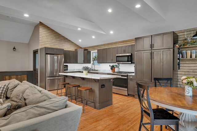 480 Logue Cir, Seneca, IL 61360 - kitchen featuring stainless steel appliances, open floor plan, a kitchen bar, light countertops, and lofted ceiling