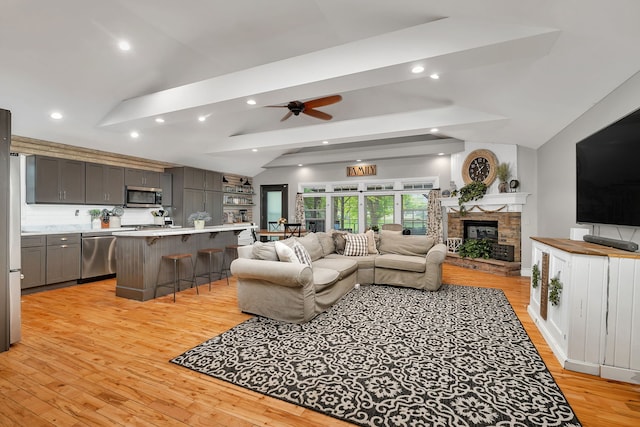 480 Logue Cir, Seneca, IL 61360 - living room with lofted ceiling, ceiling fan, light wood-type flooring, a stone fireplace, and recessed lighting