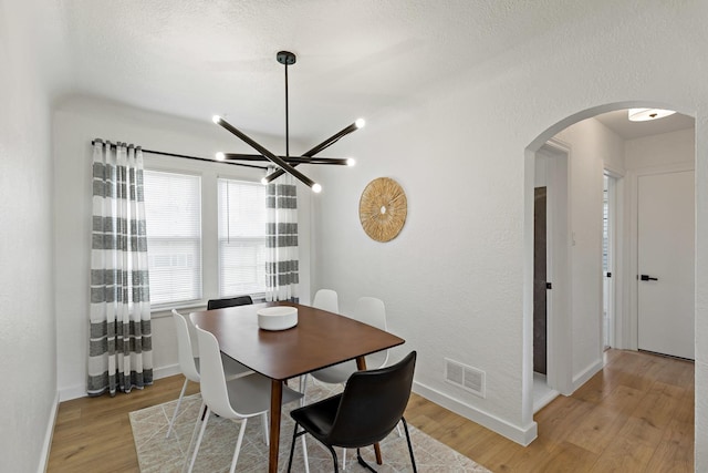 3634 177th St, Lansing, IL 60438 - dining room with arched walkways, a chandelier, light wood finished floors, and baseboards