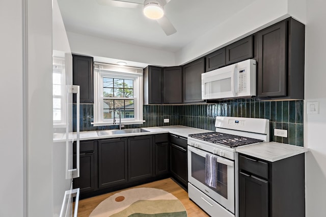 3634 177th St, Lansing, IL 60438 - kitchen featuring white appliances, a sink, light wood-type flooring, light countertops, and decorative backsplash