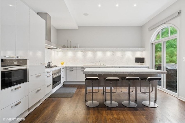 1733 S Prairie Ave, Chicago, IL 60616 - kitchen featuring appliances with stainless steel finishes, wall chimney exhaust hood, modern cabinets, and recessed lighting