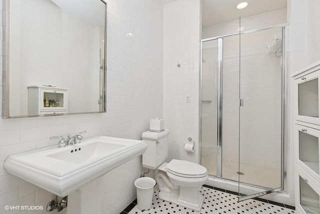 1733 S Prairie Ave, Chicago, IL 60616 - full bathroom with a stall shower, toilet, tile walls, a sink, and tile patterned floors