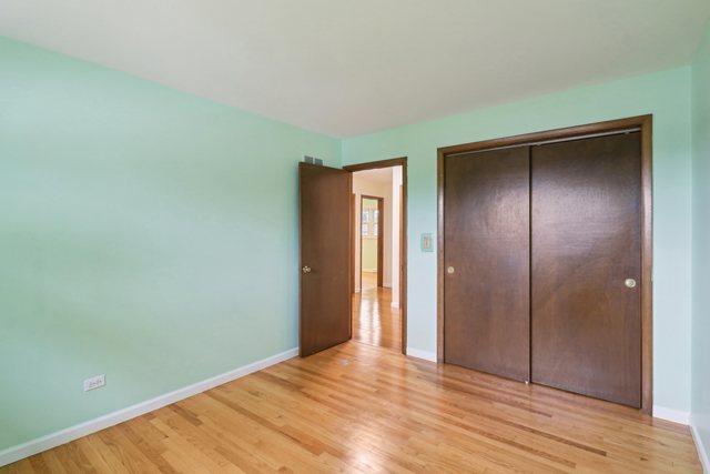 409 Wingate Dr, Schaumburg, IL 60193 - unfurnished bedroom featuring light wood-style flooring, baseboards, and a closet