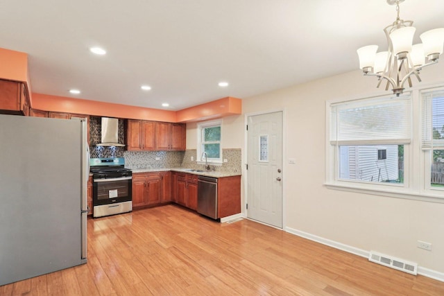 409 Wingate Dr, Schaumburg, IL 60193 - kitchen featuring stainless steel appliances, wall chimney range hood, a chandelier, brown cabinets, and backsplash
