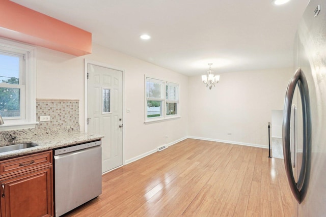 409 Wingate Dr, Schaumburg, IL 60193 - kitchen featuring stainless steel appliances, a chandelier, brown cabinets, a sink, and light wood-type flooring