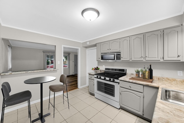 172 Nanti St, Park Forest, IL 60466 - kitchen featuring white range with gas cooktop, stainless steel microwave, ornamental molding, light countertops, and gray cabinets