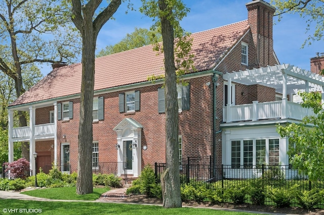 350 Elder Ln, Winnetka, IL 60093 - view of front of property featuring a balcony, a chimney, a tile roof, a pergola, and brick siding