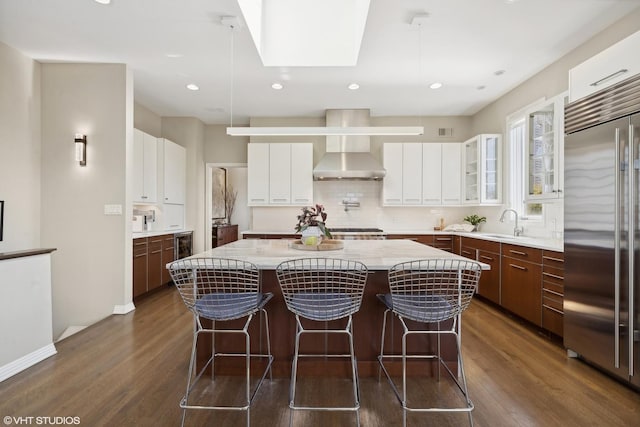 2122 N Hudson Ave, Chicago, IL 60614 - kitchen featuring stainless steel built in fridge, wall chimney range hood, dark wood-style flooring, a kitchen island, and tasteful backsplash
