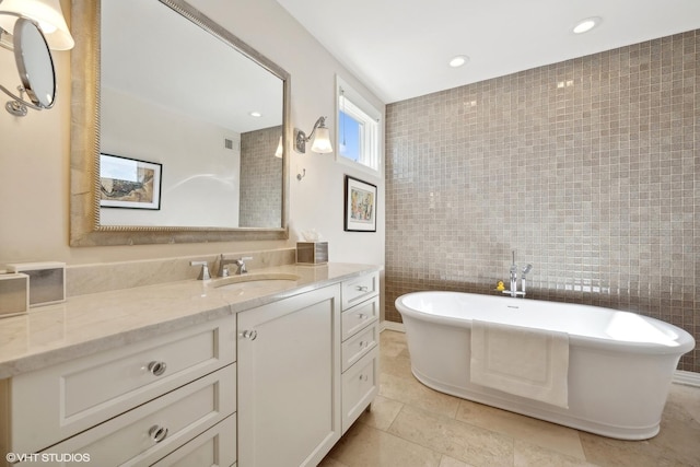 2122 N Hudson Ave, Chicago, IL 60614 - bathroom with tile walls, a freestanding tub, vanity, tile patterned floors, and recessed lighting