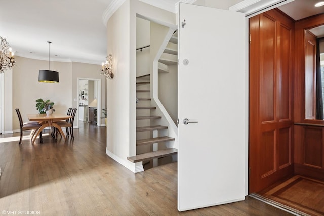 2122 N Hudson Ave, Chicago, IL 60614 - foyer entrance featuring stairway, wood finished floors, a chandelier, baseboards, and crown molding