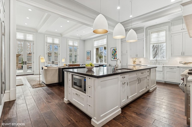542 W Dickens St, Chicago, IL 60614 - kitchen with stainless steel microwave, a sink, dark wood-type flooring, an island with sink, and beamed ceiling
