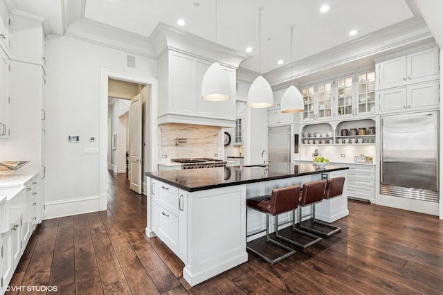 542 W Dickens St, Chicago, IL 60614 - kitchen featuring crown molding, dark wood-style flooring, dark countertops, tasteful backsplash, and a kitchen bar