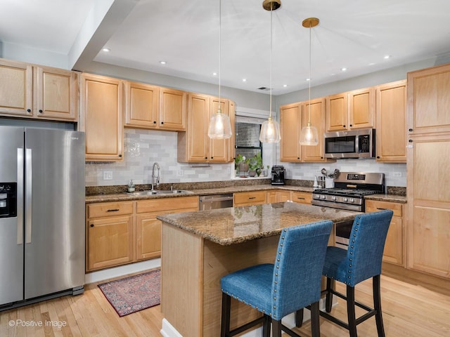 2636 N Fairfield Ave Unit 1N, Chicago, IL 60647 - kitchen featuring appliances with stainless steel finishes, a sink, light brown cabinetry, light wood-type flooring, and a kitchen bar