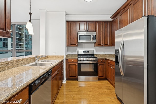 420 E Waterside Dr Unit 1103, Chicago, IL 60601 - kitchen featuring appliances with stainless steel finishes, light wood-style floors, a sink, light stone counters, and hanging light fixtures
