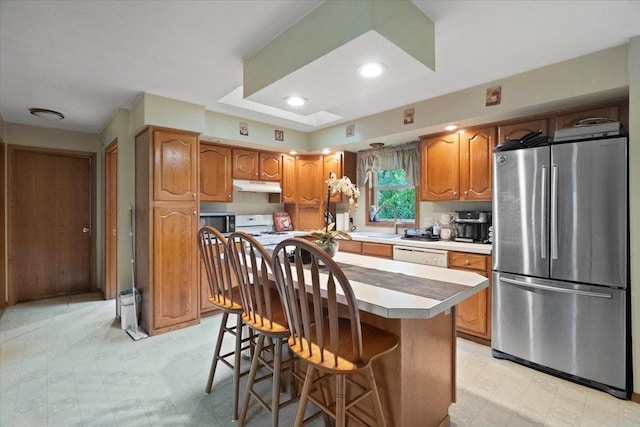 26630 W Il Route 134, Ingleside, IL 60041 - kitchen with freestanding refrigerator, under cabinet range hood, brown cabinetry, light flooring, and recessed lighting