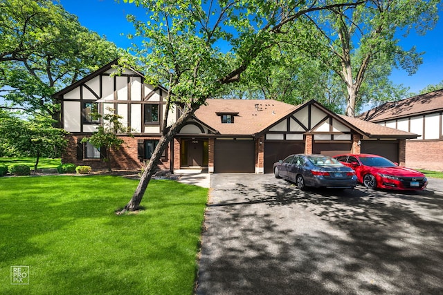 11210 Sycamore Ln Unit 61D, Palos Hills, IL 60465 - tudor-style house with an attached garage, driveway, brick siding, a front lawn, and stucco siding