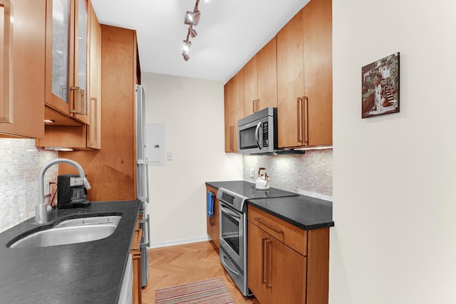 1325 N State Pkwy Unit 17C, Chicago, IL 60610 - kitchen with stainless steel appliances, a sink, backsplash, dark countertops, and glass insert cabinets