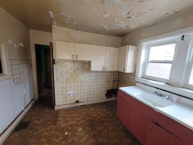 7118 S Morgan St, Chicago, IL 60621 - kitchen featuring a sink, tile walls, white cabinetry, and light countertops