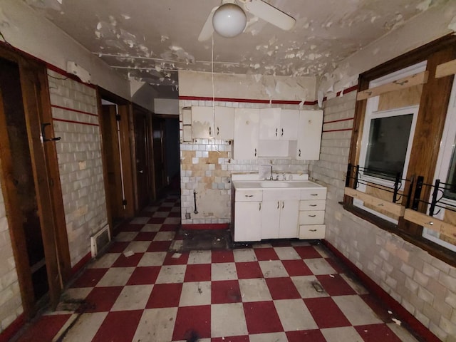 7118 S Morgan St, Chicago, IL 60621 - kitchen with tile patterned floors, white cabinetry, light countertops, a sink, and a ceiling fan