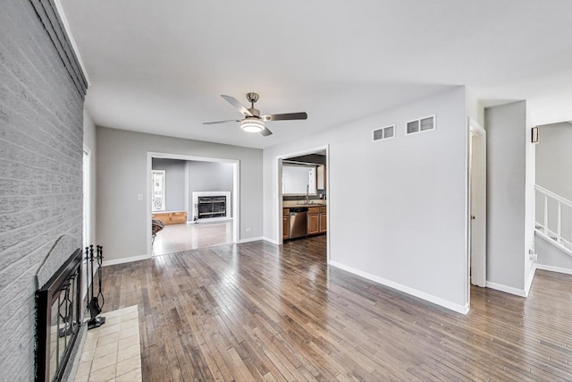 6S009 Steeple Run Dr, Naperville, IL 60540 - unfurnished living room featuring a fireplace, ceiling fan, a sink, hardwood / wood-style floors, and stairs
