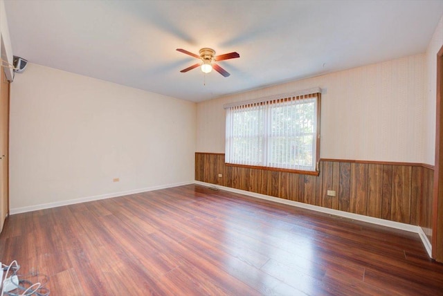 38059 N Holdridge Ave, Beach Park, IL 60087 - unfurnished room featuring a ceiling fan, a wainscoted wall, wood finished floors, wooden walls, and baseboards