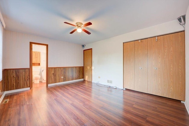 38059 N Holdridge Ave, Beach Park, IL 60087 - unfurnished bedroom with wood finished floors, wainscoting, a closet, wood walls, and connected bathroom